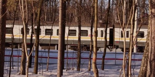 在阳光明媚的冬日里，一列火车行驶在公路上