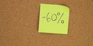 把促销60%的贴纸贴在软木板上。俯视图的笔记板。办公室里满是记录。在办公室或家里留下提醒。