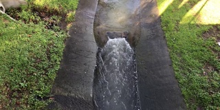 雨水排水沟在长满草的边缘流动