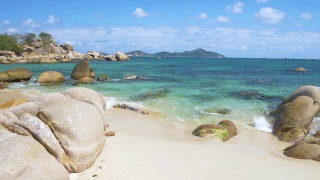 慢镜头:华丽的热带海滩绿松石透明的水独特的巨石，金兰芽潭越南东南海岸旅游目的地，沙漠海滩没有人清澈的蓝天视频素材模板下载