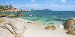慢镜头:华丽的热带海滩绿松石透明的水独特的巨石，金兰芽潭越南东南海岸旅游目的地，沙漠海滩没有人清澈的蓝天