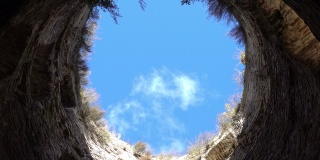 从底部看蓝天白云被石墙包围，希望自由和幸福，中世纪堡垒的塔在晚上。俄罗斯普斯科夫地区的伊兹博斯克市。