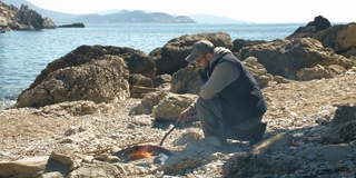 地中海的海浪拍打着石头和沙子，岩石附近的蓝色大海。