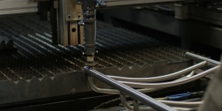 现代工业激光机床采用CNC，金属切割技术。现代工厂的钢管激光切割。激光在管道上切洞。