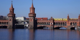 一辆黄色的地铁列车驶过柏林的奥伯本大桥