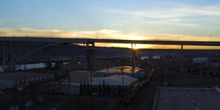 美国俄勒冈州波特兰，2021年11月。# 25。从空中俯瞰仓库区，火车在等待，日落时弗里蒙特大桥的景观在上升。