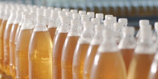 在现代饮料厂，带着瓶装果汁或水的传送带。现代生产的甜苏打水
