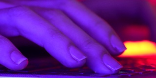 女性程序员、游戏玩家或工作人员在夜晚霓虹灯下使用笔记本电脑键盘。整天工作概念，成功女性，女人故事