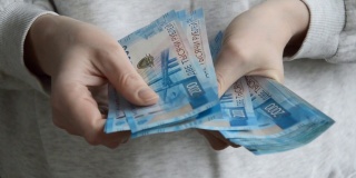 一位妇女用手数钞票。俄罗斯的钱,卢布。