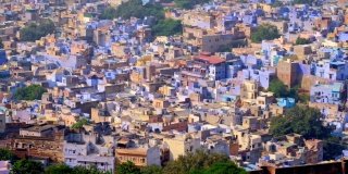 焦特布尔的蓝色城市鸟瞰图。从印度拉贾斯坦邦梅兰加尔堡(Mehrangarh Fort)俯瞰，清晨婆罗门住宅上空，蓝色的房屋和鸟儿在飞翔。相机缩小