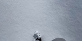 冬天穿登山靴的人走在雪地上，新雪上留下脚印。从眼睛看到的景色。冬季户外活动。阳光明媚的。新年,圣诞节。脚近距离。4 k