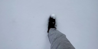 冬天穿登山靴的人走在雪地上，新雪上留下脚印。从眼睛看到的景色。广角视图。冬季户外活动。新年，圣诞节，4K