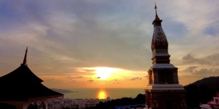 倒转日落时间推移，在日落在泰国普吉岛海滩上的彩色天空。摄于巴东山的一座寺庙