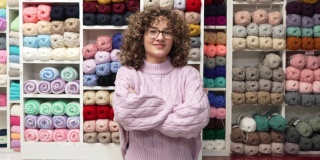 年轻的白人女性企业主，在她的织物商店商店
