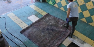 用刷子对地毯进行化学清洗。
