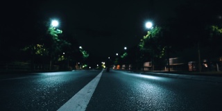 从后面可以看到一个男人在夜晚独自走在废弃的道路中间
