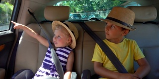 戴着草帽的可爱的小朋友们坐在车的后座上