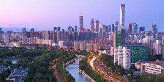 4 k。4096 x2304p。25 fps。时间流逝，视频CBD的城市景观与汽车交通流的主要道路在河边在黄昏/日落在北京，中国