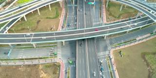 俯视汽车行驶在多层次公路上的日落。高速公路多层次交叉公路穿过中国市中心。高速公路立交桥与汽车、卡车和公共汽车的交汇处。