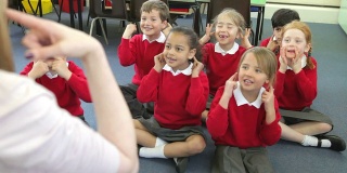 小学生模仿老师唱歌的动作