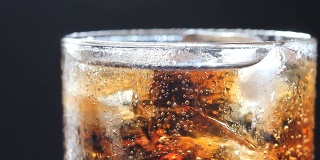 Cola bubble with ice and glass, abstract background.