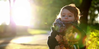孩子在秋天的公园里扔黄叶。