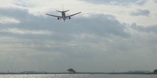 一架飞机进入东京国际机场降落模式的低角度视图。