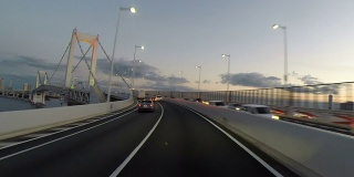 夕阳下的司机穿过东京彩虹桥。