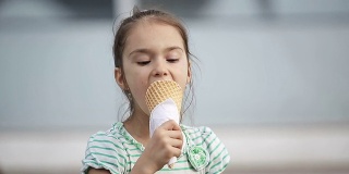 漂亮的小女孩在街上吃冰淇淋