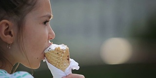 漂亮的小女孩在街上吃冰淇淋