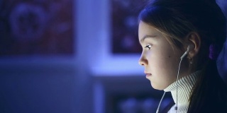 孩子们在晚上使用电脑的肖像。