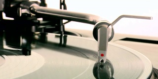 DJ转盘。把针掉在旋转的黑胶唱片机上，然后拿回去。特写美丽的白色背景。
