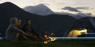 三个朋友在自然山户外露营的夜晚用篝火取暖的场景-高清视频片段