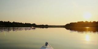 美丽的水景，游客在夕阳下划着皮划艇