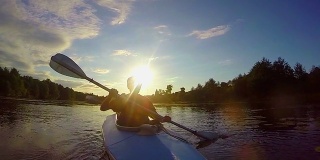 日落时人们划船的剪影，旅行的，慢镜头