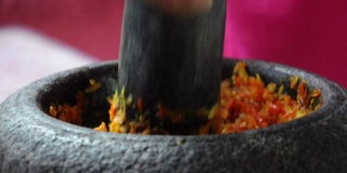 用手把香料捣成石头，这是泰国传统的咖喱酱制作方法