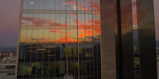 天线:日落时分在商业摩天大楼周围飞行