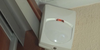 一个简单的白色运动检测器安装在墙角