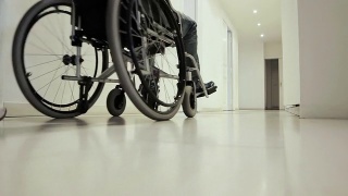 轮椅上的病人被抬过医院的走廊视频素材模板下载