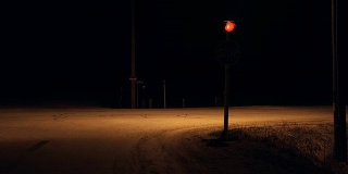 停止标志红灯闪烁在黑暗的农村农村十字路口