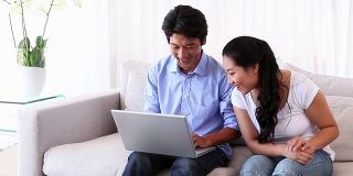 亚洲男人给他女朋友看笔记本电脑上的东西