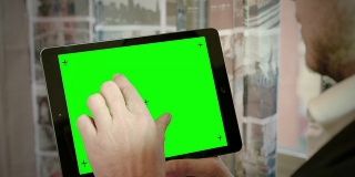 年轻人在平板电脑上打字:绿色屏幕，阿尔法通道