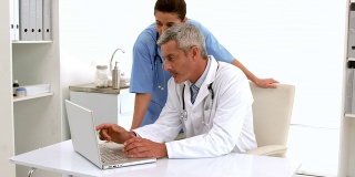 慢动作医生在桌子上使用电脑键盘