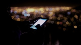 晚上在户外用手机发送短信的人视频素材模板下载
