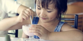 亚洲小孩在休息时间吃冰淇淋。