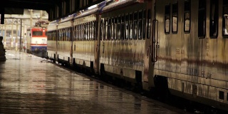 车站站台潮湿，列车车厢站在机车移动的背景下