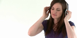 快乐的白人女人戴着耳机听音乐