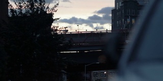 火车在黄昏时穿过纽约市大桥。