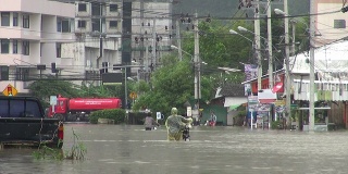 人们走在被洪水淹没的街道上