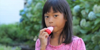 可爱的亚洲女孩舔她的冰棒
